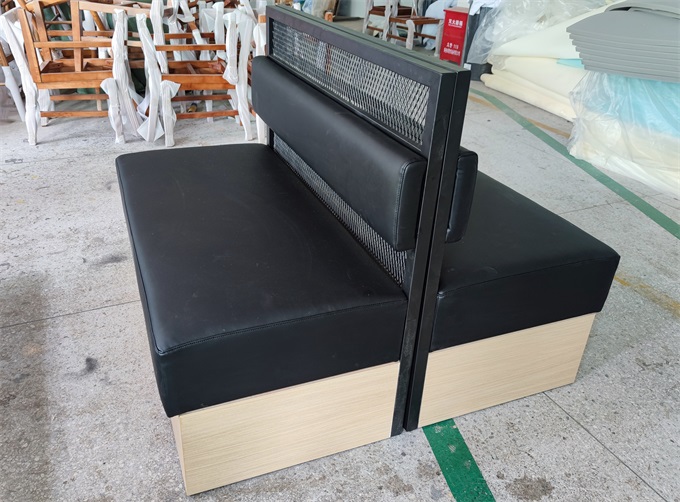 Modern club booth seating in black faux leather with metal frame.