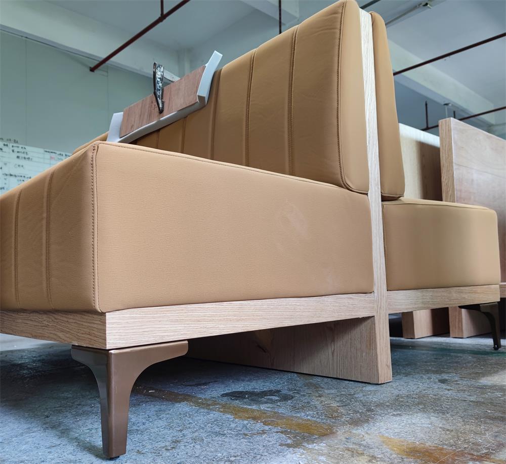 Close-up of modern booth seating with metal legs and stain-resistant fabric, designed for high-traffic commercial spaces