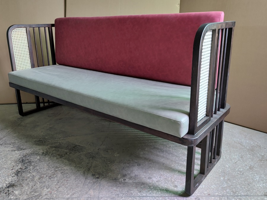 Front view of modern restaurant booth sofa with pink backrest, grey seat cushion, and dark wood frame, ideal for hot pot restaurants.