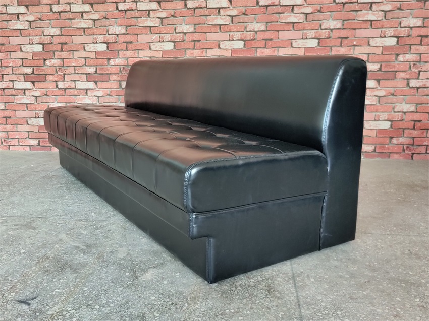 A side view of the black faux leather KTV sofa, showing the thickness of the cushions and the ergonomic backrest