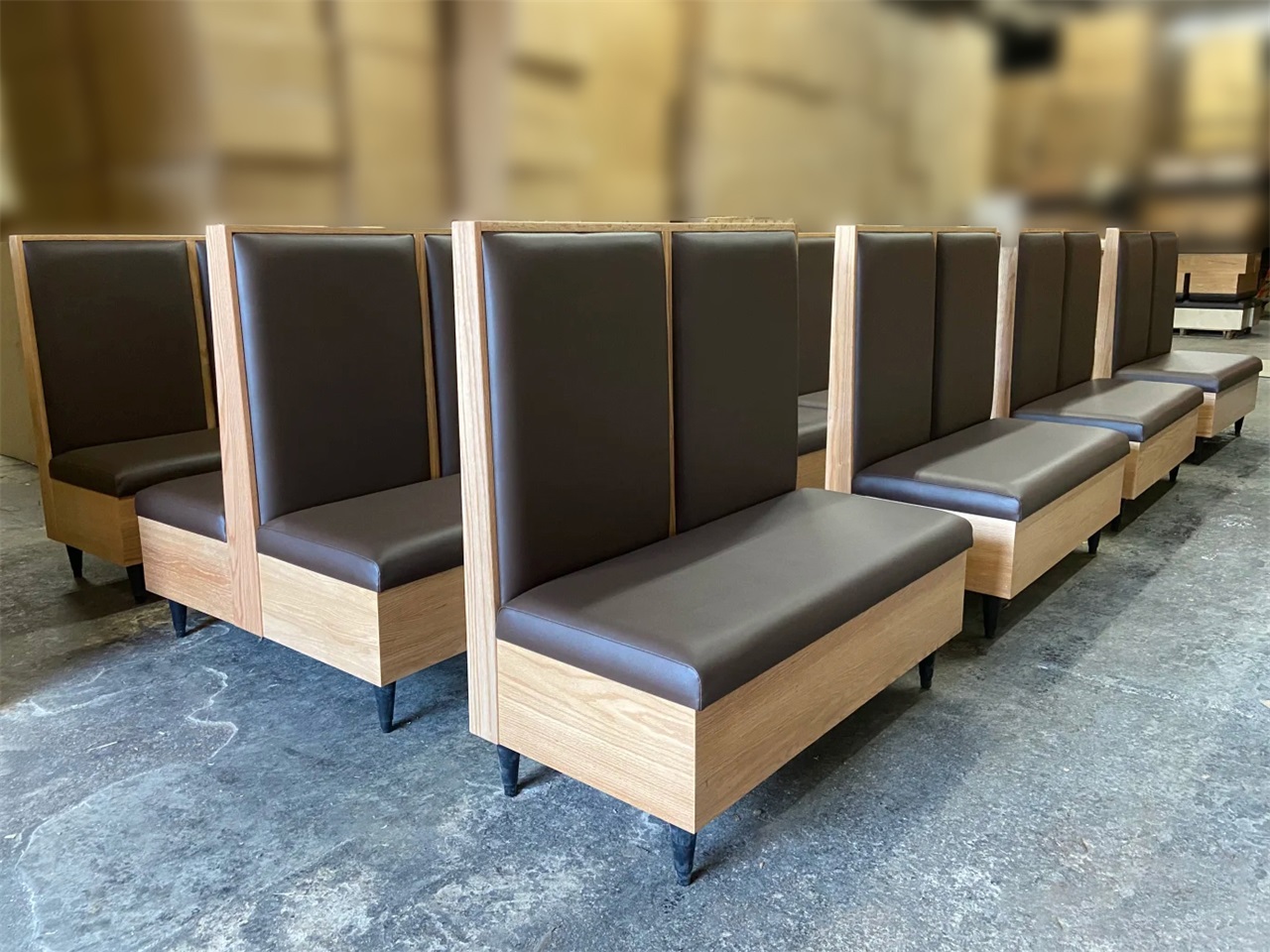 Custom upholstered restaurant booth with a wooden high-back design, featuring durable construction and comfortable seating for commercial dining spaces