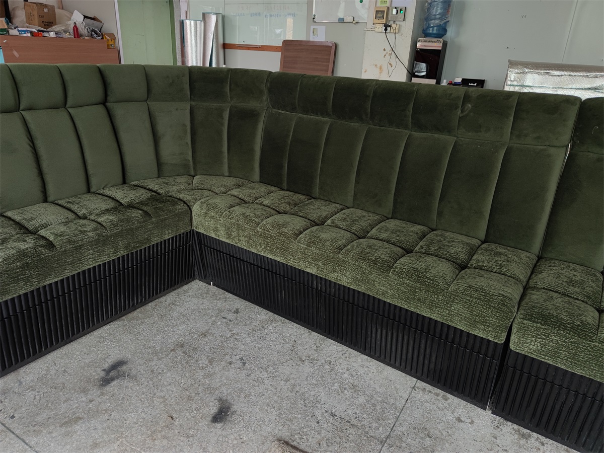 Luxury green velvet restaurant booth with an ergonomic L-shaped design and elegant detailing