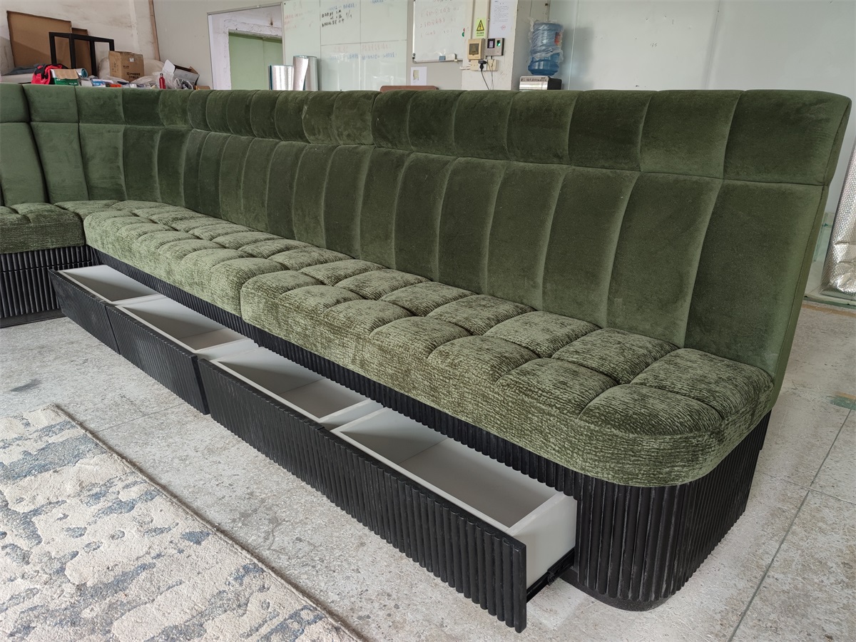 Modern velvet booth seating with a ribbed black wood base, adding sophistication to a commercial setting.